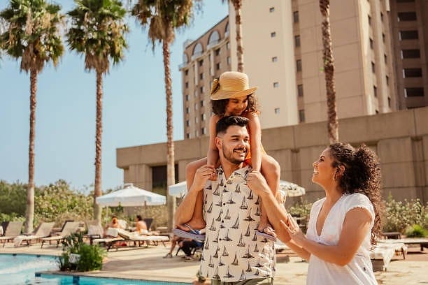 Family enjoying a hotel pool deck on a sunny day